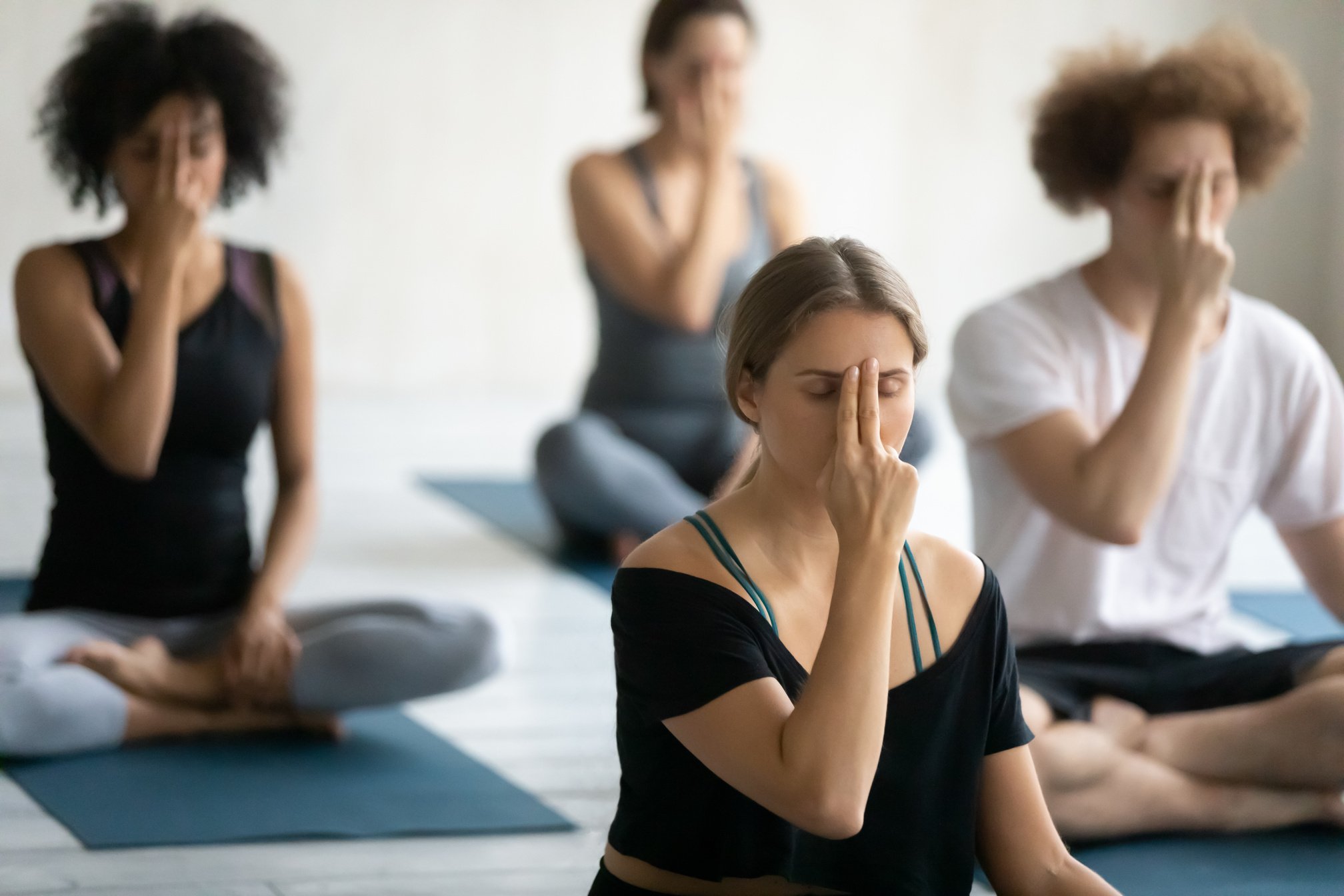 Group of multiethnic people doing yoga practice Alternate Nostril Breathing